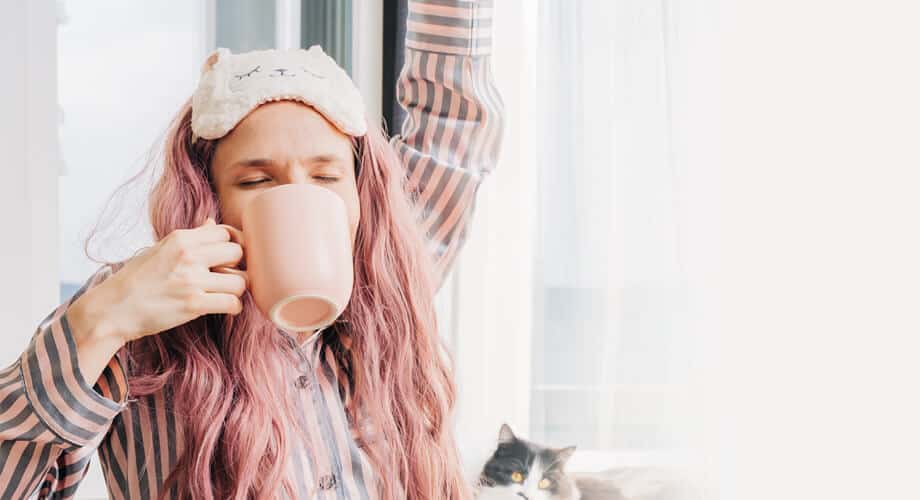 sonhar com café: mulher acordando e bebendo uma xícara de café