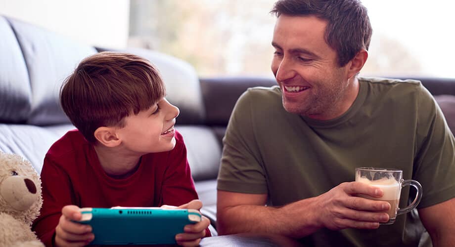 pai e filho jogando jogos de café em videogame portátil