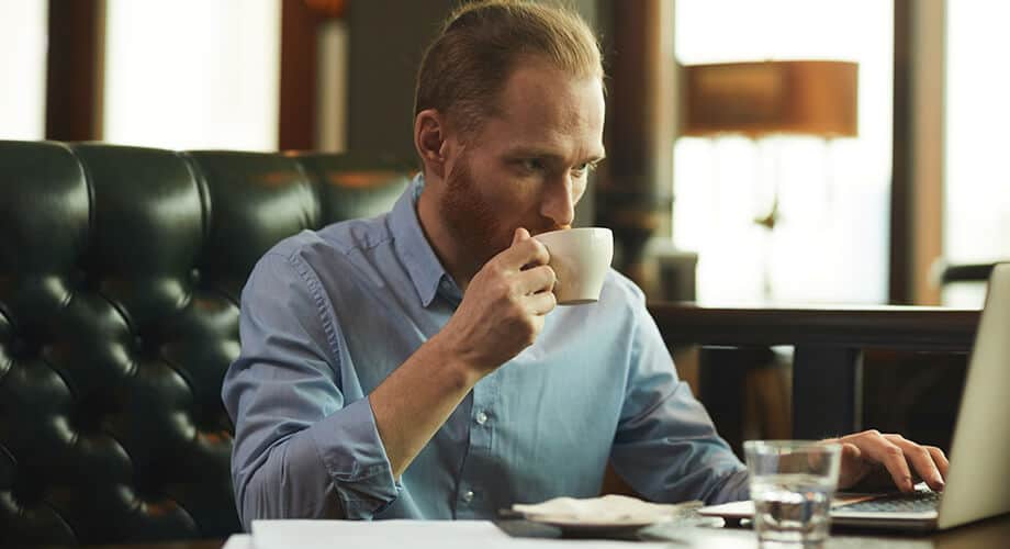 imagem de um homem se deliciando com um café fraco em cafeteria